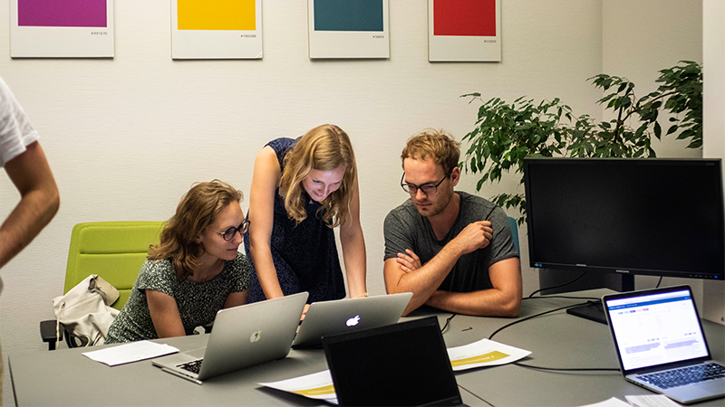 Menschen arbeiten zusammen am Laptop