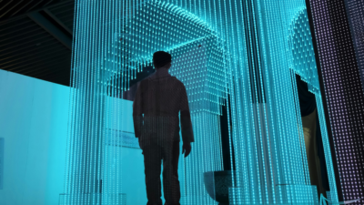 A person in a black jacket stands in a blue-lit room, symbolizing the integration of People Analytics in the workplace to enhance decision-making and employee dynamics.