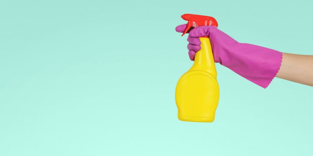Das Bild zeigt eine Hand mit Putzhandschuh und Sprühflasche. Das soll zeigen, dass dieser Blogbeitrag versucht Vorurteile über Wissenschaft aufzuräumen.